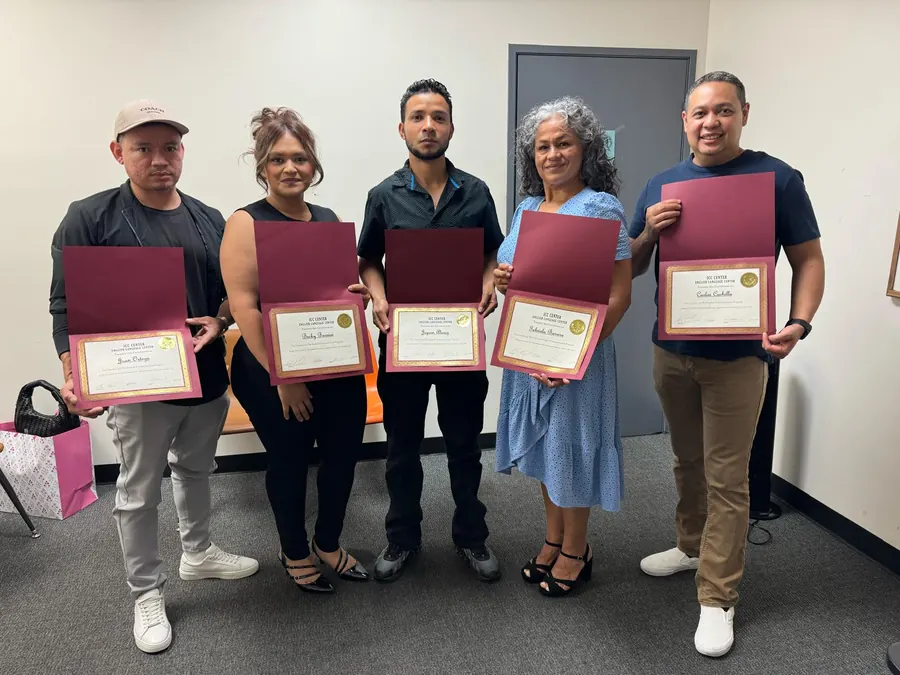 Cinco graduados de ICC&nbsp;Center con sus certificados en carpetas color vino